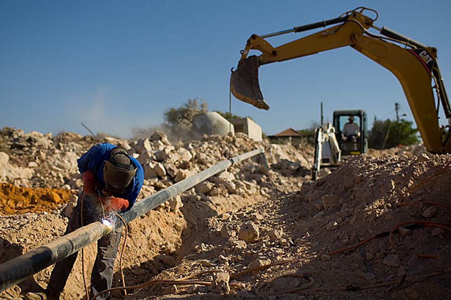 **FILE** A Palestinian man works at a construction site on Sept. 27 in the West Bank Jewish settlement of Yakir, south of the Palestinians town of Nablus. (Associated Press)