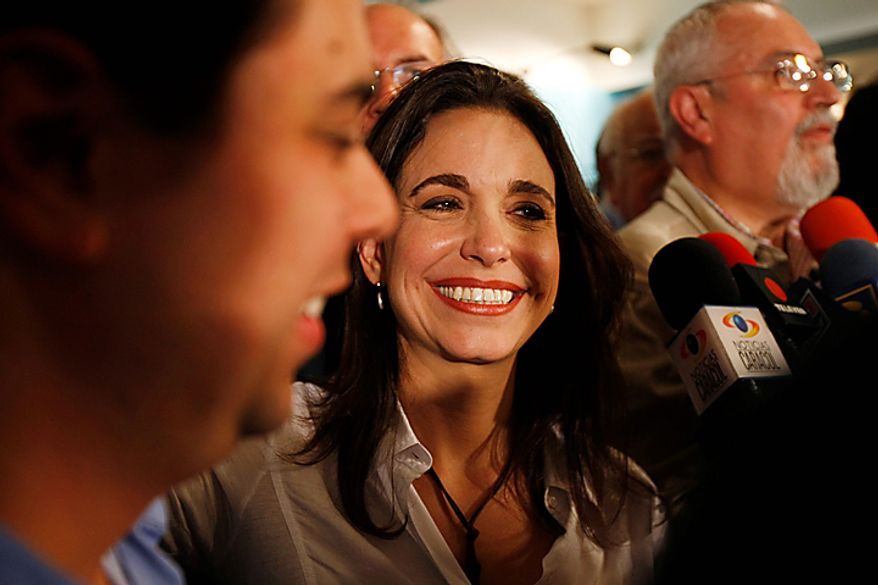 Independent opposition legislative candidate Maria Corina Machado, center, is congratulated after she was elected as congress woman in Caracas, Venezuela, Monday , Sept 27, 2010. President Hugo Chavez held on to a congressional majority in elections Sunday, but his opponents made gains that could help them challenge his grip on power. (AP Photo/Leonardo Ramirez)