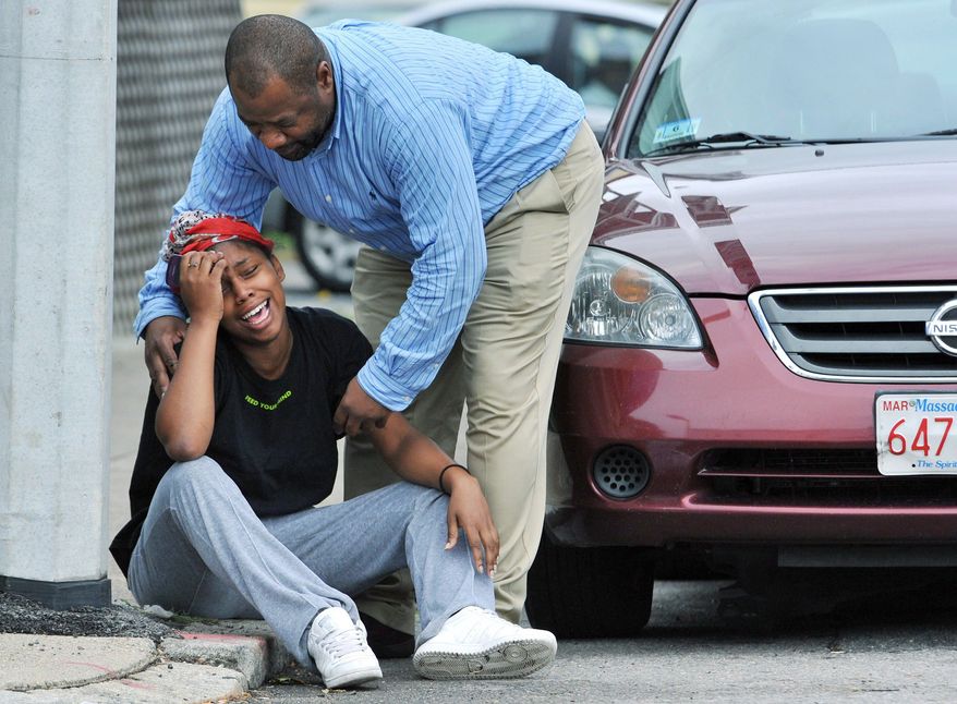 A man comforts a grieving woman near the scene of the shooting, which occurred in Matapan, a neighborhood that had 14 homicides in 2010 before Tuesday, compared to six in the same time last year. (Associated Press)