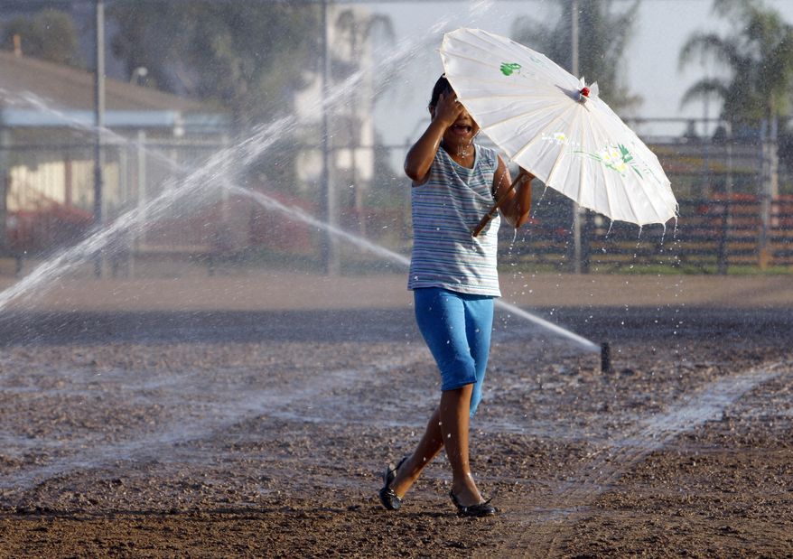 A girl plays in the sprinklers to beat the heat in Monterey Park, Calif., on Monday, Sept. 27, 2010. Downtown Los Angeles' record temperature of 113 degrees was part of an onslaught of temperatures well over 100 degrees in many California cities ranging from Anaheim, home of Disneyland, to San Luis Obispo on the usually balmy Central Coast. (AP Photo/Nick Ut)