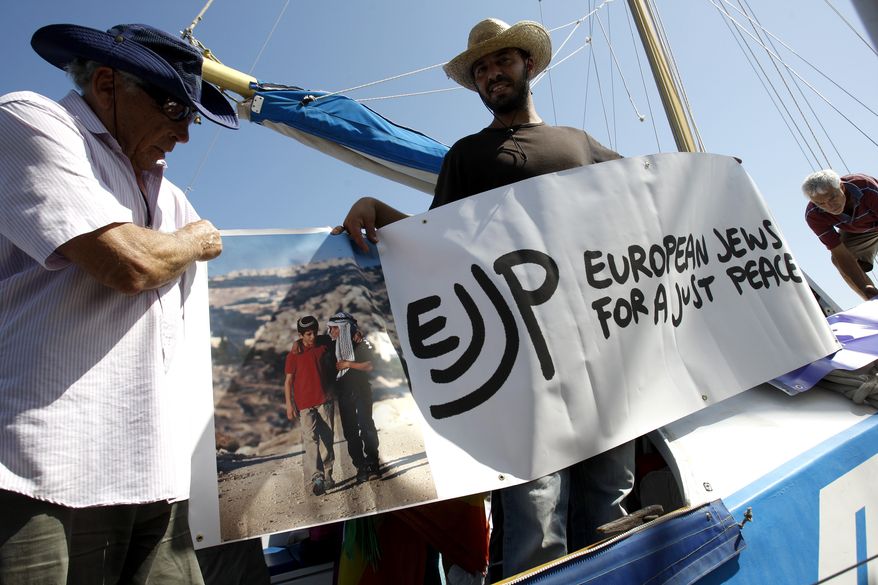 Jewish activists aboard hold a banner before sets sail from Famagusta harbor in the Turkish-occupied north of ethnically divided Cyprus in a bid to breach the Israeli naval blockade of Gaza on Sunday, Sept. 26, 2010. The trip came nearly four months after Israeli commandos boarded a flotilla of Gaza-bound ships, killing nine activists. (AP Photo/Petros Karadjias)
