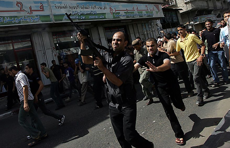 A relative of Palestinian Awni Abdul Hadi, 19, fires his gun into the air during his funeral in the al-Bureij refugee camp in central Gaza on September 28, 2010. Israeli air strikes in Gaza killed three men Palestinian medics said. UPI/Ismael Mohamad