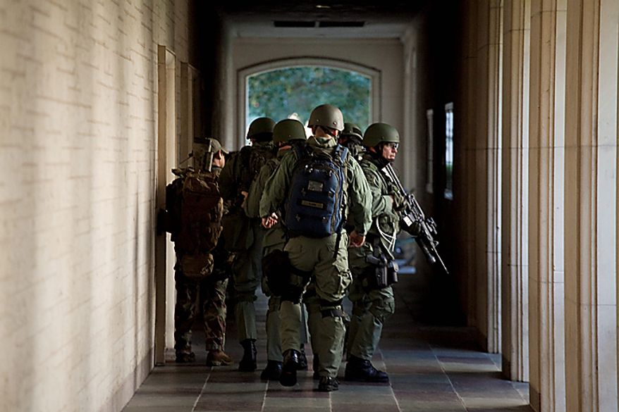 Soldiers prepare to enter Calhoun Hall at the University of Texas in Austin, Texas on Tuesday Sept. 28, 2010. A gunman opened fire Tuesday inside the Perry-Castaneda Library then fatally shot himself, and police are searching for a possible second suspect, university police said. (AP Photo/The Daily Texan, Tamir Kalifa)