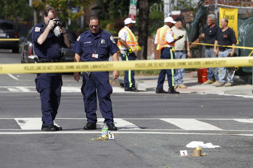 Washington Police officers collect evidence at a crime scene on 13th and U Street in Northwest Washington, Tuesday, Sept. 28, 2010. Police are searching for a suspect in a shooting and subsequent car crash that left one person dead and two others wounded on Washington's popular U Street corridor (AP Photo/Manuel Balce Ceneta)