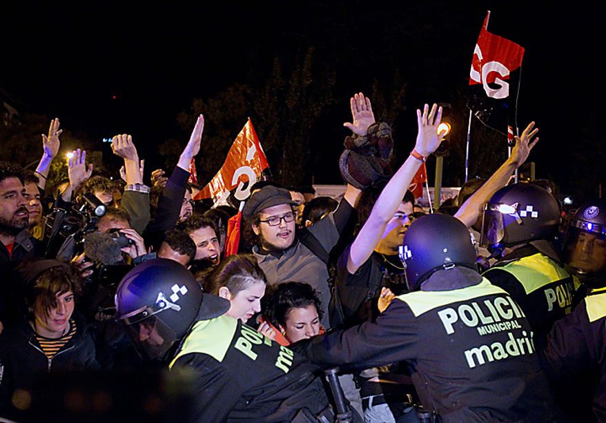Police push back pickets outside a bus depot during a nationwide general strike organized by the Spanish unions, in Madrid, Wednesday, Sept. 29, 2010. Picketers hurled eggs at buses and blocked trucks from delivering produce to wholesale markets as Spanish workers went on a general strike Wednesday to protest austerity measures imposed by a government struggling to slash its budget deficit and overcome recession. (AP Photo/Paul White)