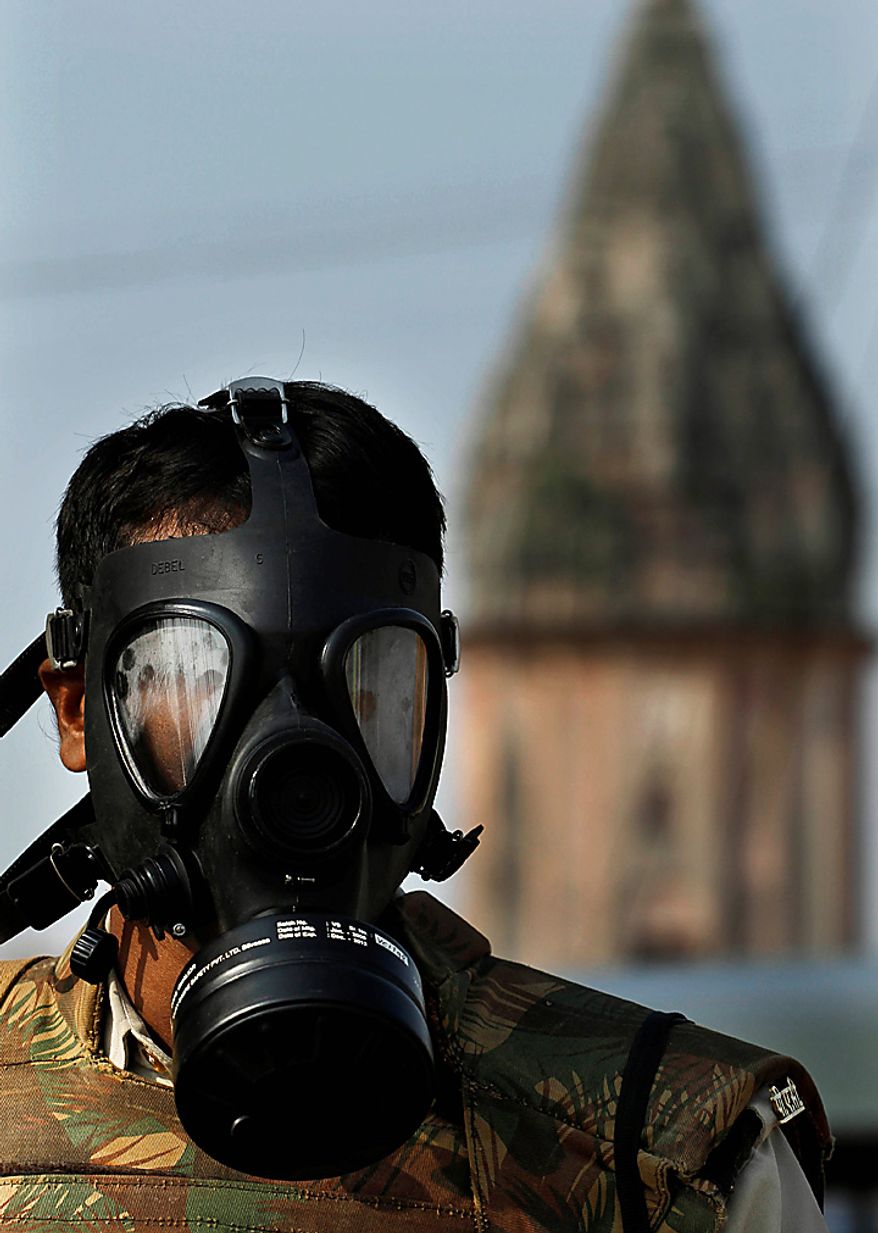 An Indian policeman stands vigil in the backdrop of a temple, ahead of a potentially explosive court verdict on whether Hindus or Muslims should control a disputed holy site in Ayodhya, India, Thursday, Sept. 30, 2010. Police have arrested more than 10,000 people to prevent them from inciting violence, while another 100,000 had to sign affidavits saying they would not cause trouble after the verdict, a top official said. A 16th-century Babri Mosque, Hindus claim was erected at the birthplace of their god Rama, stood at the disputed site in the town of Ayodhya before it was razed by Hindu hard-liners in 1992, setting off violence that killed 2,000 nationwide. (AP Photo/Rajesh Kumar Singh)