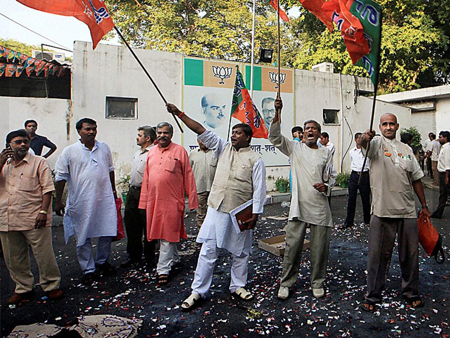 Hindu nationalist Bharatiya Janata Party workers celebrate after Ayodhya verdict in New Delhi, India, Thursday, Sept. 30, 2010. An Indian court ruled Thursday that a disputed holy site that has sparked bloody communal riots across the country in the past should be divided between the Hindu and Muslim communities. However, the court gave the Hindu community control over the section where the now demolished Babri Mosque stood and where a small makeshift tent-shrine to the Hindu god Rama rests. While both Muslim and Hindu lawyers vowed to appeal to the Supreme Court, the compromise ruling seemed unlikely to set off a new round of violence, as the government had feared.(AP Photo)