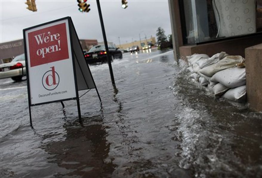 Many businesses along 21st Street in Norfolk, Va., around Llewellyn Avenue placed sandbags in front of their doorways to keep storm water from entering the stores on Thursday, Sept. 30, 2010. (AP Photo/The Virginian-Pilot, Stephen M. Katz)