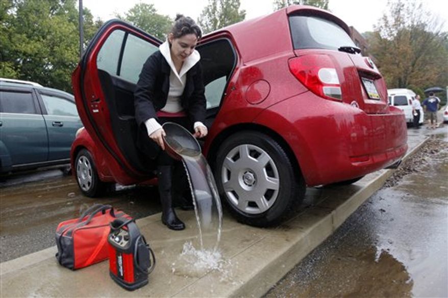 Amel Sincere empties out her car after receded floodwaters submerged the parking lot of the Waterford Apartments in Havertown, Pa., Friday, Oct. 1, 2010. (AP Photo/Matt Rourke)