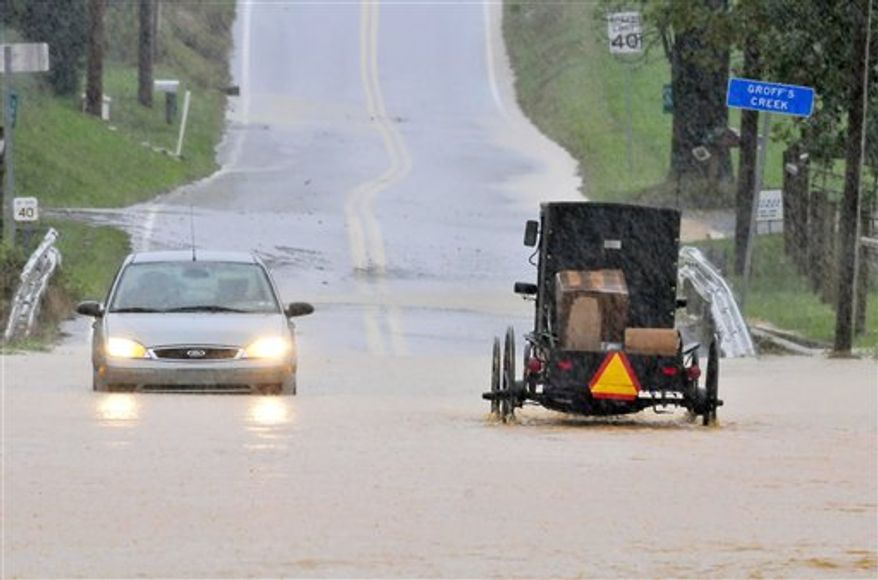 A buggy and car drive through high water on South Farmersville Road at Groff's Creek Thursday, Sept. 30, 2010 in Ephrata, Pa, Much of eastern Pennsylvania is under flood warnings as storms could bring as much as six inches of rain before leaving the area on Friday. The National Weather Service issued a tornado watch Thursday for counties stretching from Philadelphia west to York and north to Allentown. (AP Photo/Intelligencer Journal, Blaine Shahan)