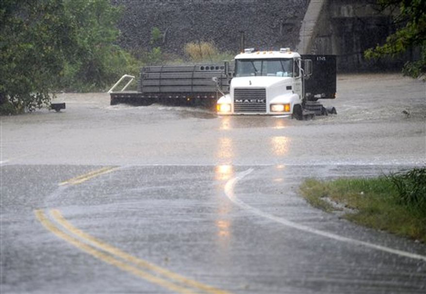 A truck makes its way through a rising Stemmers Run on Golden Ring Road in east Baltimore County, Md. A massive rainstorm drenched the East Coast from the Carolinas to Maine on Thursday, washing out commutes and wiping away months of dry weather. (AP Photo/Baltimore Sun, Jed Kirschbaum)