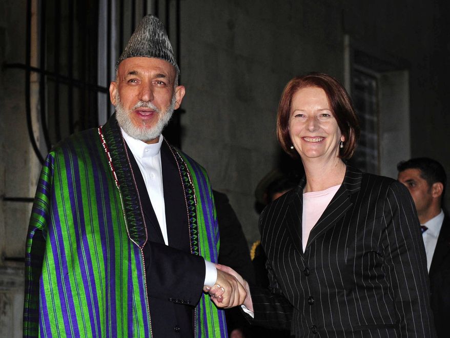Australian Prime Minister Julia Gillard is welcomed by Afghan President Hamid Karzai during their first official meeting at the presidential palace in Kabul, Afghanistan, on Saturday, Oct. 2, 2010. Ms. Gillard pledged to continue supporting the U.S.-led mission there in her first overseas trip as Australia's leader. (AP Photo/Australian Department of Defense, Raymond Vance)