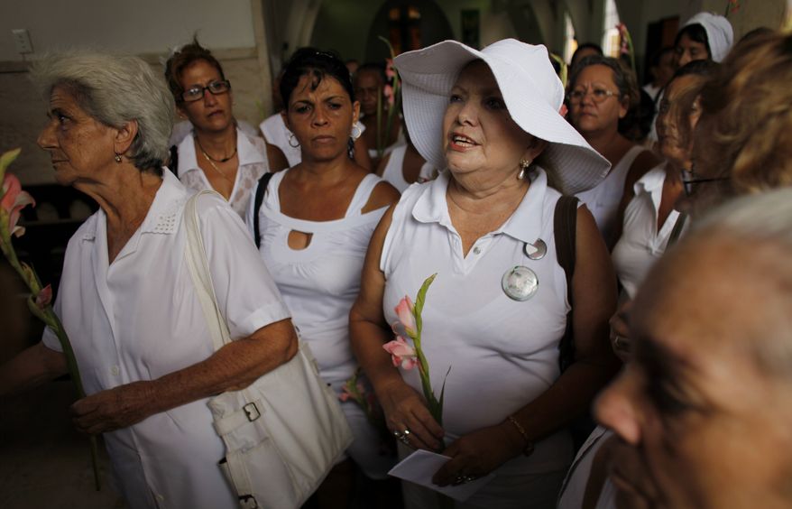 ** FILE ** Laura Pollan (right), leader of the Cuban female dissident group Ladies in White, prays during a Mass in Havana, on Sunday, Sept. 19, 2010. Cuba's Roman Catholic Church on the previous Friday revealed the names of four more political prisoners to be released into exile in Spain. (AP Photo/Javier Galeano)