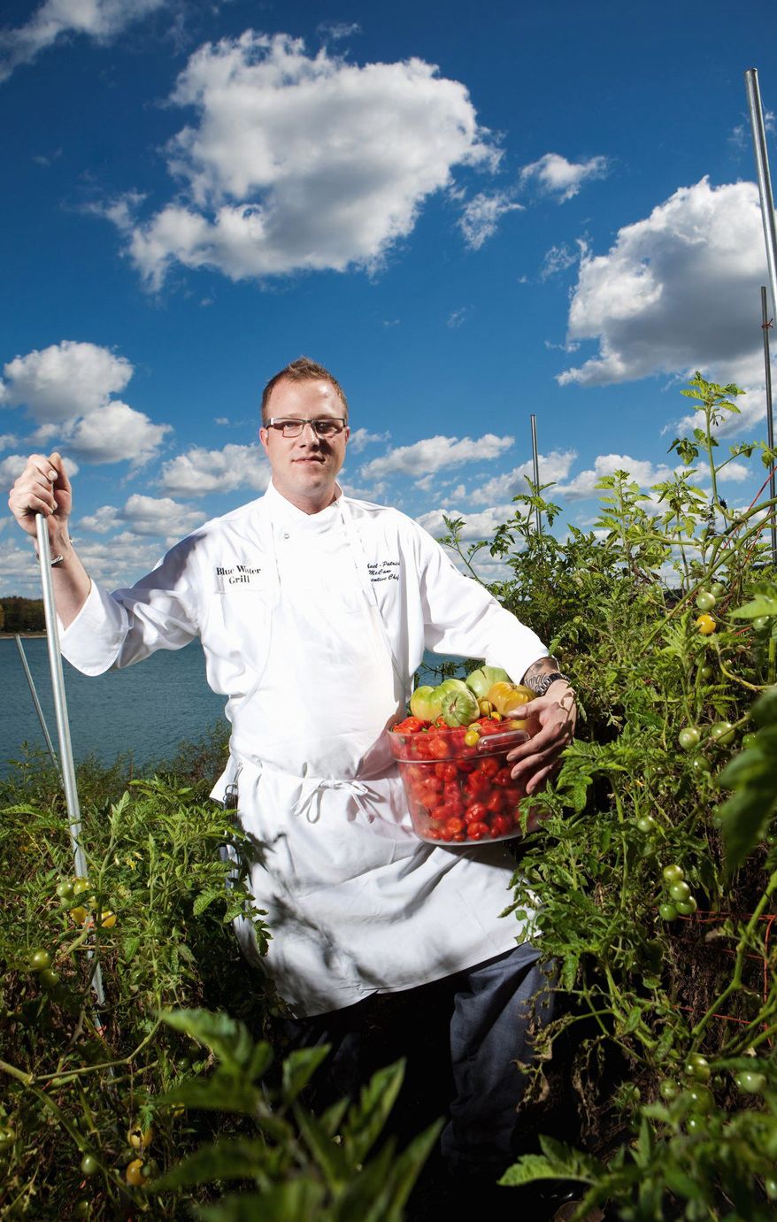 Head chef for the Blue Water Grill in Grand Rapids, Mich., Michael-Patrick McCann, does some harvesting in the vegetable garden that has replaced the restaurant's landscaping. Vegetables and herbs are picked and used for cooking on a daily basis. (Associated Press)