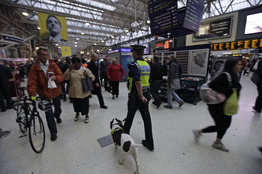 A police officer with a dog patrols a central London train station on Monday, Oct. 4, 2010. Britain's Foreign Office has upgraded its travel advice for France and Germany, warning Britons going to those countries that the threat of terrorism there is high. British Home Secretary Theresa May said that the threat of terrorism in the United Kingdom remains unchanged at "severe," meaning an attack is highly likely. (AP Photo/Lefteris Pitarakis)