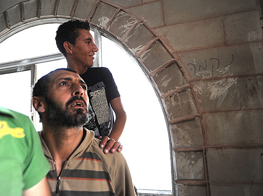 Palestinians look at Hebrew graffiti, that reads 'Revenge', in the torched and vandalized Prophet's Mosque in Beit Fajjar, north of Hebron in the West Bank, October 4, 2010, 2010. Palestinian sources said that Jewish settlers entered the mosque and torched the mosque, Koran books, prayer rugs and left Hebrew graffiti with slogans against Arabs, Muslims and Mohammad on the walls. UPI/Debbie Hill