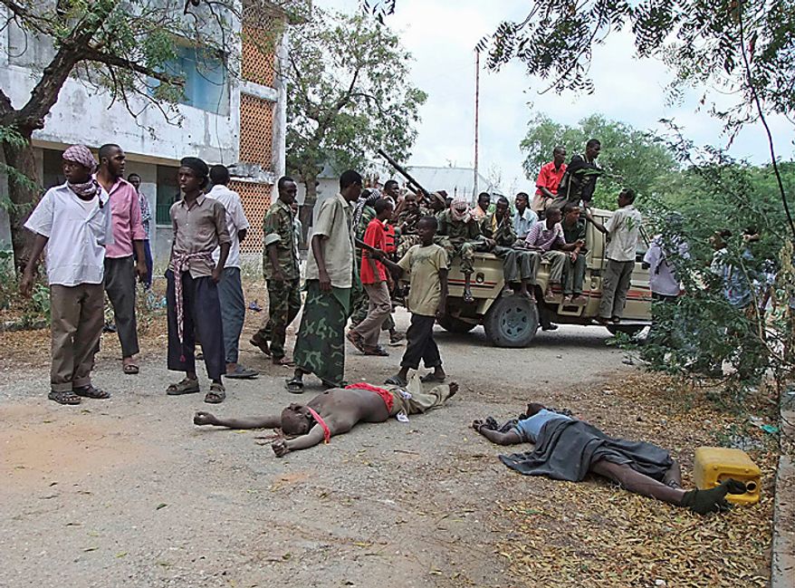 Al-Shabab militants gather near the bodies of Somali government soldiers who were killed during clashes with Islamists in southern Mogadishu's Hodon neighborhood , Somalia, Monday, Oct.4, 2010. Ali Muse, the head of Mogadishu's ambulance service, says a spike in violence the last three days in Mogadishu has killed at least 20 civilians. More than 70 people have been wounded.(AP Photo/Farah Abdi Warsameh)