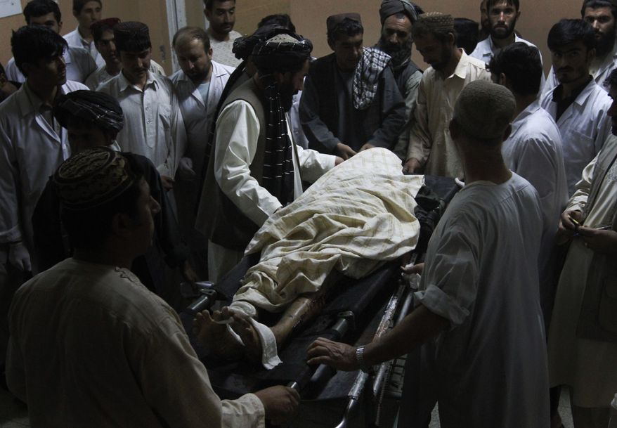 A man killed in a blast is surrounded by his relatives in a hospital in Kandahar city, south of Kabul, Afghanistan, Tuesday, Oct. 5, 2010. Two explosions rocked Kandahar on Tuesday where U.S. and Afghan forces are ramping up operations in areas long held by the Taliban. (AP Photo/Allauddin Khan)