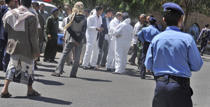 Yemeni security forces and forensics personnel attend the scene where an attack took place on a convoy carrying a senior British diplomat in capital San'a Wednesday, Oct. 6, 2010. (AP Photo)