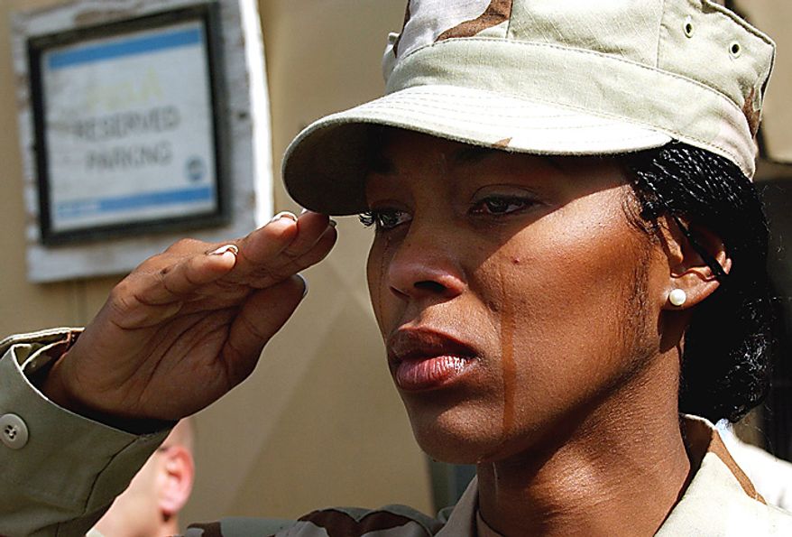 In this Monday, Sept. 11, 2006 file picture, tears run down the cheeks of U.S. Staff Sgt. Alicia Watkins from Washington D.C. as she salutes during a ceremony marking the fifth anniversary of the Sept. 11 attacks at a U.S. military base in Kabul, Afghanistan. (AP Photo/Musadeq Sadeq, File)