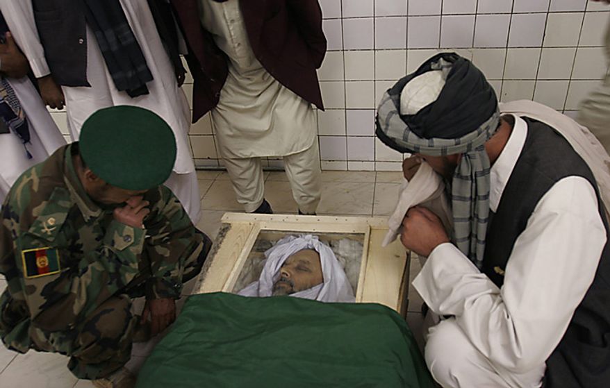 In this Monday, April 28, 2008 file picture, relatives mourn over the body of lawmaker Fazel Rahman Samkanai at the hospital in Kabul, Afghanistan. Samkanai, who was about 30 yards away from President Hamid Karzai, was killed when suspected Taliban militants attacked a ceremony marking the 16th anniversary the defeat of the Soviet invasion of Afghanistan in Kabul on Sunday. (AP Photo/Rahmat Gul, File)