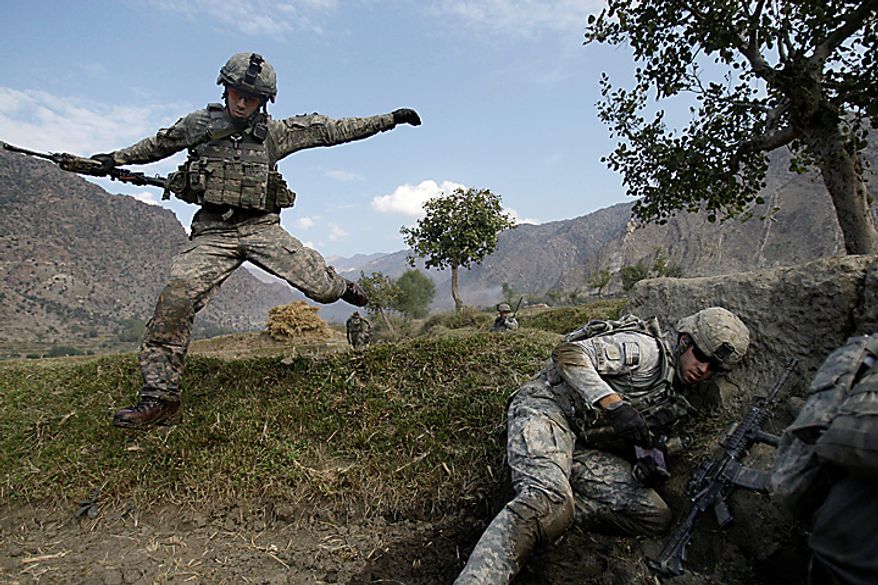 In this Nov. 3, 2009 file photo, Cpl. Casey Liffrig, left, leaps for cover as Lt. Thomas Goodwin gets down as Taliban fighters ambush U.S. soldiers from the 2nd Battalion, 12th Infantry Regiment, 4th Brigade Combat Team, 4th Infantry Division during a patrol in the Pech Valley of Afghanistan's Kunar province. (AP Photo/David Guttenfelder, File)
