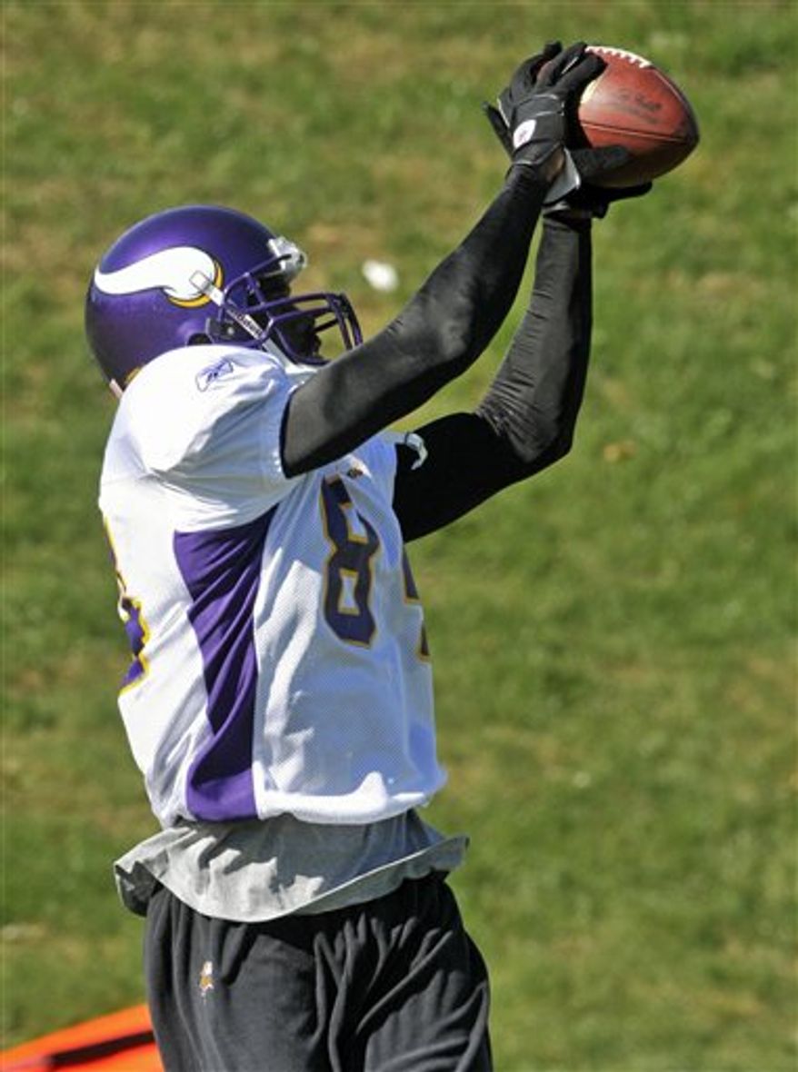 Minnesota Vikings quarterback Brett Favre, left, throws to wide receiver Randy Moss during NFL football practice, Thursday, Oct. 7, 2010 in Eden Prairie, Minn. Moss was traded Wednesday to the Vikings by the New England Patriots. (AP Photo/Jim Mone)