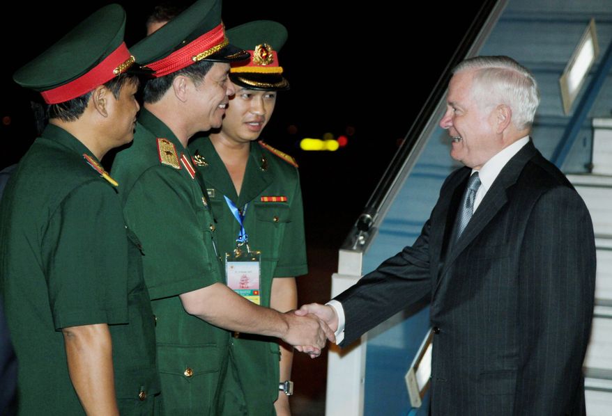 Defense Secretary Robert M. Gates is greeted by (from left) Senior Col. Nguyen Hong Quang, Maj. Gen. Nguyen Huu Manh and 2nd Lt. Nguyen Thang Anh as he deplanes from a U.S. military aircraft upon his arrival at the Noi Bai International Airport in Hanoi on Sunday. Mr. Gates is in Vietnam to reassure jittery Southeast Asian nations this week that the United States won't cede its longtime role as the pre-eminent military power in the Pacific as Chinese naval ambitions expand. (AP Photo)