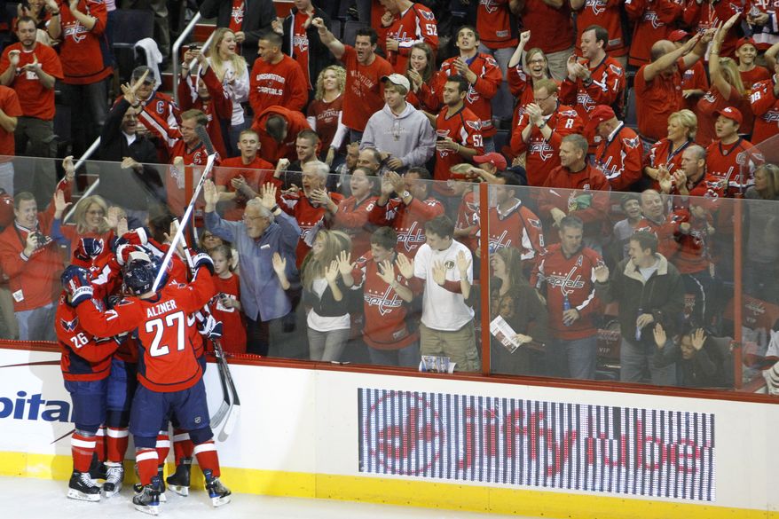 Washington Capitals players and fans celebrate the team's first goal by John Carlson against the New Jersey Devils during the first period of an NHL hockey game in Washington on Saturday, Oct. 9, 2010. (AP Photo)