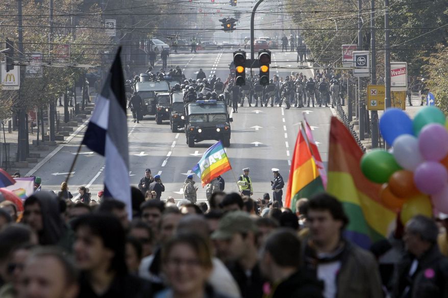 Serbian riot police gather as a gay price parade goes moves along a street in Belgrade, Serbia, on Sunday, Oct. 10, 2010. More than 140 people were hurt and more than 200 arrested, officials said, as police clashed with hundreds of far-right protesters who tried to disrupt the march. (AP Photo/Darko Vojinovic)