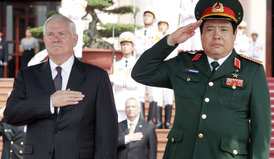 Defense Secretary Robert M. Gates (left) and Vietnam&#39;s minister of defense, Gen. Phung Quang Thanh, stand together during the playing of &quot;The Star-Spangled Banner&quot; during a Guards of Honor ceremony at the Ministry of Defense in Hanoi on Monday, Oct. 11, 2010. (AP Photo/Carolyn Kaster, Pool)