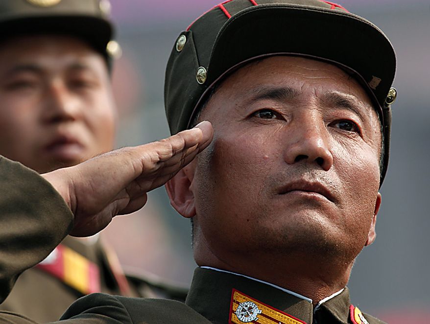 A North Korean soldier salutes as he marches in a massive military parade marking the 65th anniversary of the communist nation's ruling Workers' Party in Pyongyang, North Korea on Sunday, Oct. 10, 2010. This year's celebration comes less than two weeks after Kim Jong Il's re-election to the party's top post and the news that his 20-something son would succeed his father and grandfather as leader. (AP Photo/Vincent Yu)