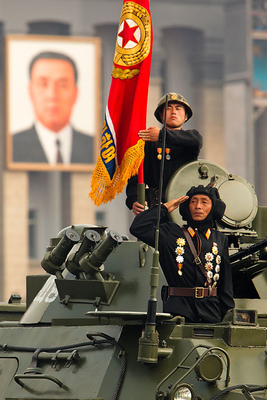 Members of the North Korean military salute during a parade commemorating the 65th anniversary of the Korea Worker's Party in Pyongyang, North Korea, on Sunday, Oct. 10, 2010. North Korean heir apparent Kim Jong Un stood at his father's right side today as they reviewed troops, tanks and missiles in a Pyongyang military parade. Photographer: Dieter Depypere/Bloomberg