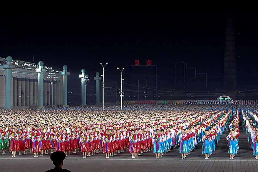 Performers dance in Kim Il Sung square during a ceremony commemorating the 65th anniversary of the Korea Worker's Party in Pyongyang, North Korea, on Sunday, Oct. 10, 2010. North Korean heir apparent Kim Jong Un stood at his father's right side today as they reviewed troops, tanks and missiles in a Pyongyang military parade. Photographer: Dieter Depypere/Bloomberg