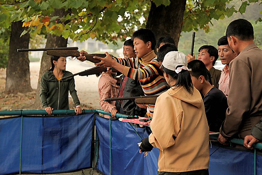 A man aims an air-rifle at game booth in a park in Pyongyang, North Korea, on Monday, Oct. 11, 2010. North Korean heir apparent Kim Jong Un stood at his father's right side today as they reviewed troops, tanks and missiles in a Pyongyang military parade. Photographer: Dieter Depypere/Bloomberg