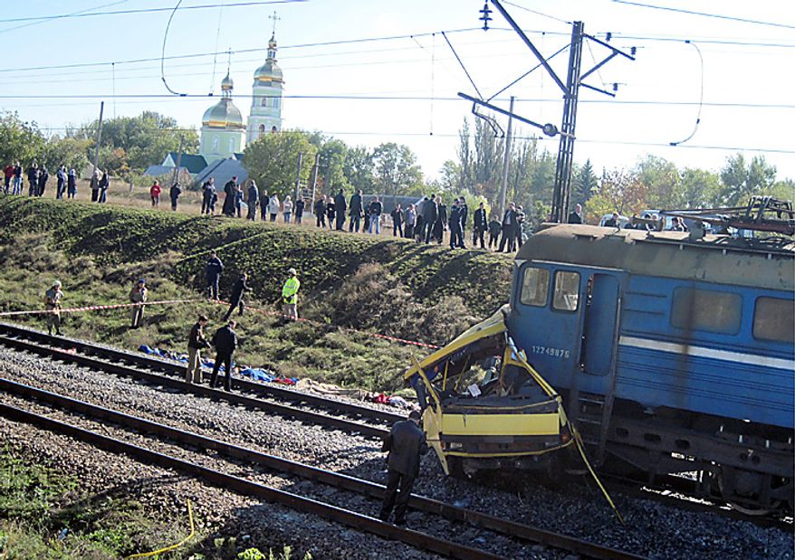 Victims bodies lie at the side of the track at the scene of an accident outside the town of Marhanets, Ukraine, Tuesday, Oct. 12, 2010 after the bus attempted to cross the track, ignoring a siren that indicated an oncoming train. At least 40 people were killed  officials at the Ministry of Emergency Situations said. Another eleven people were injured. Road and railway accidents are common in Ukraine, where the roads are in poor condition, vehicles are poorly maintained, and drivers and passengers routinely disregard safety and traffic rules. (AP Photo)