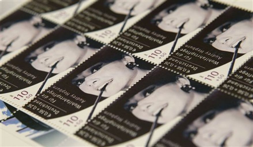 Auctioneer Elisabeth Schlegel presents a sheet with ten stamps showing U.S. actress Audrey Hepburn in Berlin, Germany, Wednesday, Oct. 13, 2010. The stamps will be auctioned in Berlin next Saturday for UNICEF and the Audrey Hepburn childrens foundation. (AP Photo/Michael Sohn)