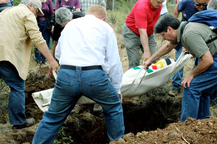 Friends and relatives carry Steve Sall&#39;s body to a grave at the White Eagle Memorial Preserve, a natural burial ground outside Goldendale, Wash. Sall, who died from complications from Lou Gehrig&#39;s disease, chose to be buried in this private forest. (Associated Press)