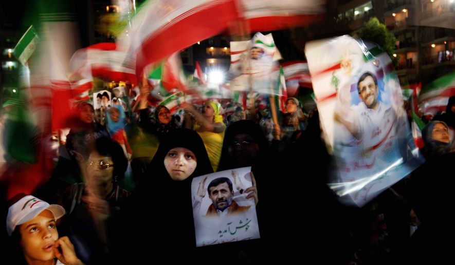 Hezbollah supporters hold up posters of Iranian President Mahmoud Ahmadinejad before his speech in Lebanon Wednesday. His fierce opposition to Israel is popular. (Associated Press)