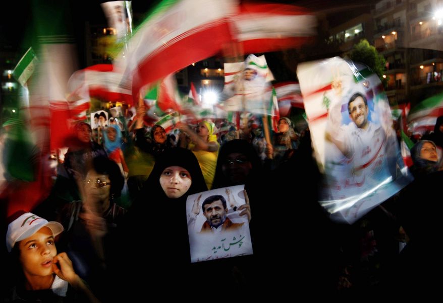 Hezbollah supporters hold up posters of Iranian President Mahmoud Ahmadinejad before his speech in Lebanon Wednesday. His fierce opposition to Israel is popular. (Associated Press)