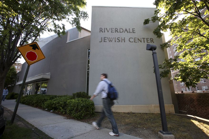 In this May 21, 2009, file photo, a man walks past the Riverdale Jewish Center in the Bronx borough of New York. Four men snared in an FBI terrorism sting were convicted Monday, Oct. 18, 2010, in a plot to blow up New York City synagogues and shoot down military planes. (AP Photo/David Goldman, File)