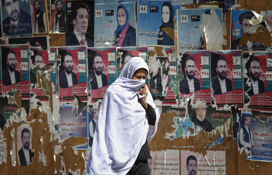 An Afghan woman walks past election posters of parliamentarian candidates in Kabul, Afghanistan on Wednesday, Sept. 22, 2010. Afghan authorities said it was too early to judge the validity of the country's parliamentary ballot despite observers' reports of widespread fraud in the vote that was to help consolidate its shaky democracy. (AP Photo/Musadeq Sadeq)