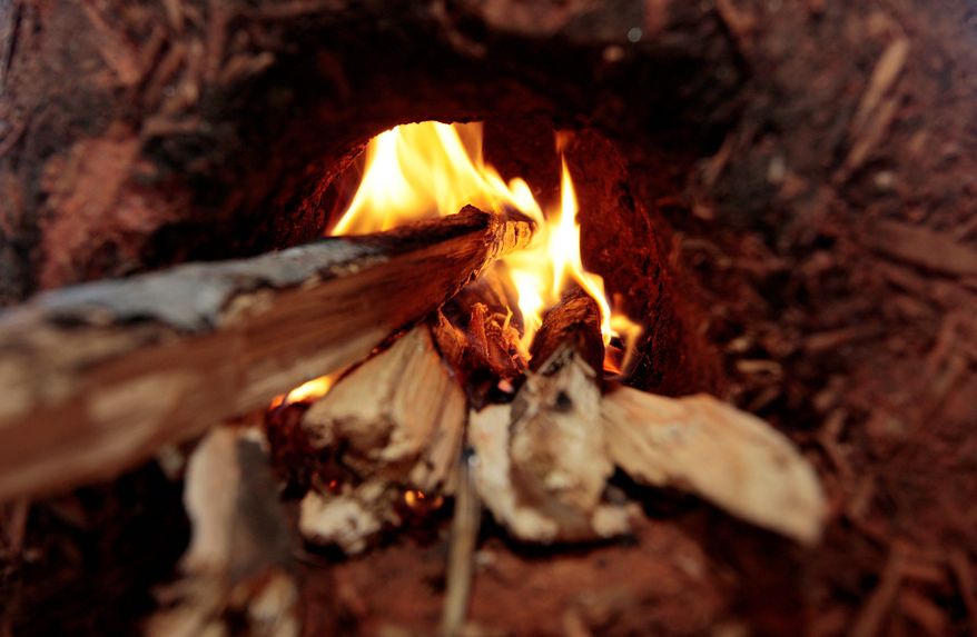 A small fire burns in one of the ovens. Servants in Faith and Technology provides the training for building them in rural Alabama. (Associated Press)
