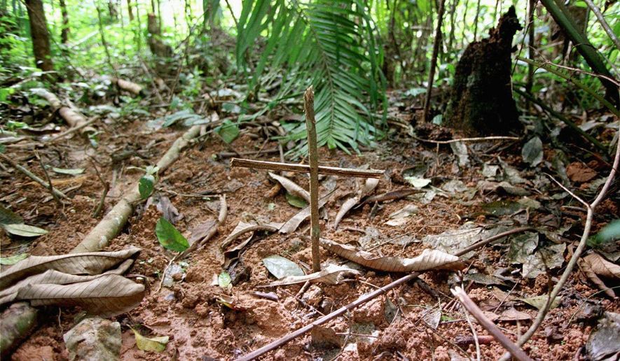 A cross marks graves near a refugee camp, about 25 miles south of Kisangani, Congo, in May 1997. The discovery of mass graves spurred probes that led to a U.N. report, which accuses invading Rwandan troops of killing tens of thousands of Hutus in 1996 and 1997. (Associated Press)