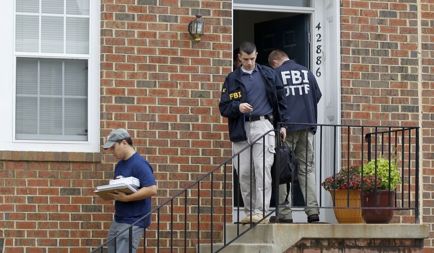 FBI investigators leave the home of Farooque Ahmed in Ashburn, Va., on Wednesday. Mr. Ahmed was arrested and charged with trying to help people posing as al Qaeda operatives planning to bomb subway stations around the nation&#39;s capital, the FBI said. (Associated Press)