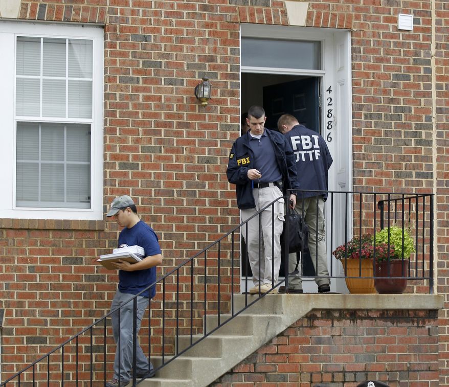 FBI investigators leave the home of Farooque Ahmed in Ashburn, Va., on Wednesday. Mr. Ahmed was arrested and charged with trying to help people posing as al Qaeda operatives planning to bomb subway stations around the nation's capital, the FBI said. (Associated Press)