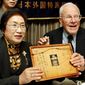Franklin Hobbs and Chie Takekawa hold a framed letter and a photo of her sister at a press conference in Tokyo on Thursday. As an American GI fighting on Iwo Jima in World War II, Mr. Hobbs found the letter, photo and a now-framed drawing of an air-raid drill (below) on a fallen Japanese soldier in 1945 and took them home as a souvenirs. (Associated Press)