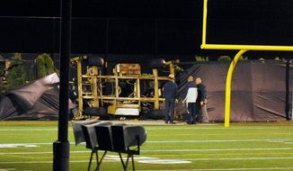 Emergency personnel examine the spot where a scissor-lift tower in which student Declan Sullivan had been taping Notre Dame football practice toppled in heavy winds. (Notre Dame Observer via Associated Press)