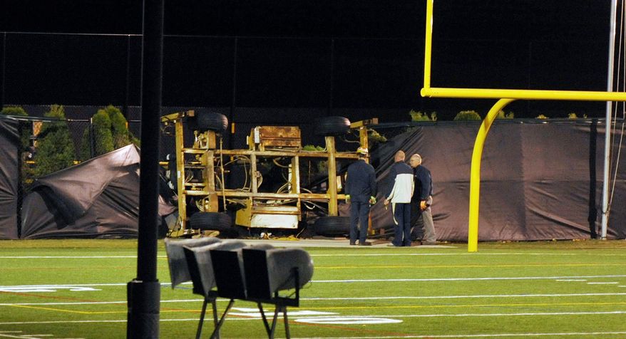 Emergency personnel examine the spot where a scissor-lift tower in which student Declan Sullivan had been taping Notre Dame football practice toppled in heavy winds. (Notre Dame Observer via Associated Press)