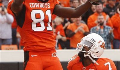 Oklahoma State wide receiver Justin Blackmon, left, celebrates with teammate Michael Harrison following a touchdown against Nebraska in the second quarter of an NCAA college football game, Saturday, Oct. 23, 2010, in Stillwater, Okla. (AP Photo/Sue Ogrocki)